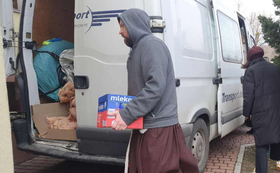 A Capuchin friar load donated food onto a truck